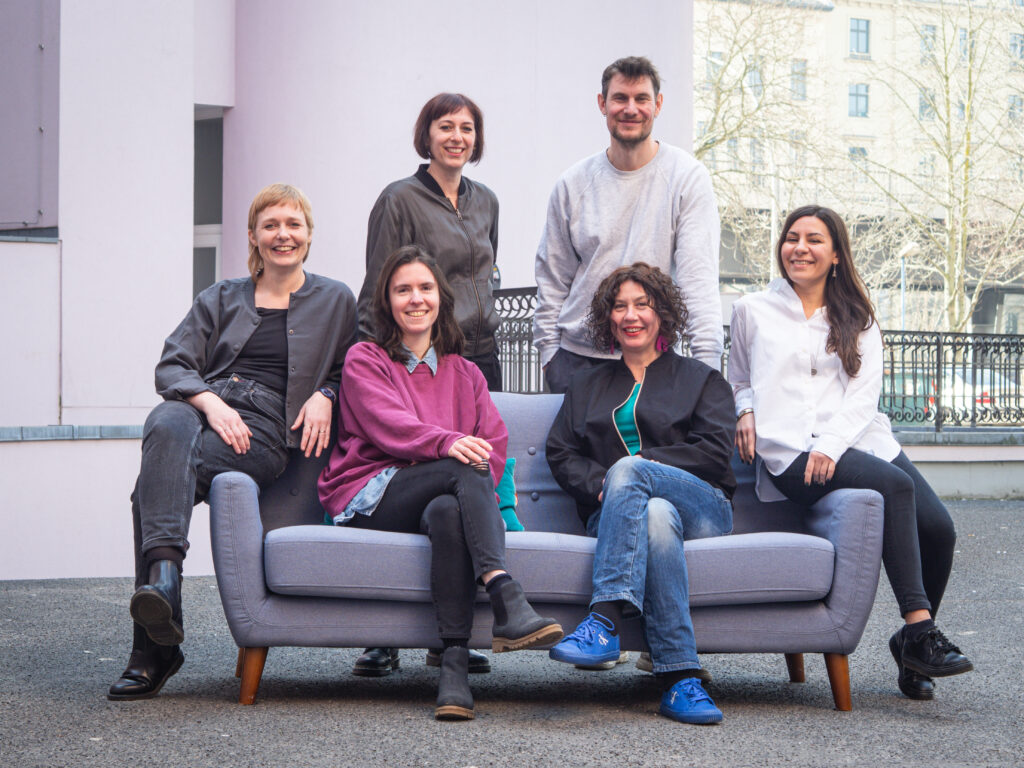 Das Team von SmartDe, sechs Menschen um eine Couch gruppiert